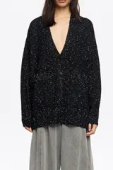 Cárdigan largo de punto negro con efecto jaspeado (neps) en blanco, de corte oversize, escote en pico pronunciado, manga larga y bolsillos de plastrón.