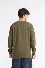 Buzo de cuello redondo Quiksilver Basic Crew, color verde militar, con manga larga y puños y cintura elastizados. Incluye un pequeño logo bordado en el pecho.