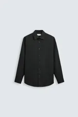 Camisa blanca de manga larga con cuello italiano y cierre frontal de botonadura. Corte regular fit.