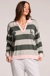 Sweater de rayas horizontales grises y verde oscuro, con cuello polo y escote en V en color rosado, puños y ruedo rosados, y parches bordados en el pecho.