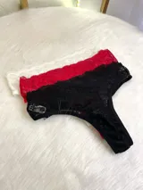 Pack de tres bombachas tipo vedetina colaless confeccionadas íntegramente en encaje con diseño floral. El set incluye una unidad en color negro, una en blanco y una en rojo.