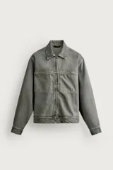 Sobrecamisa de corte regular fit confeccionada en denim de algodón color gris con efecto lavado. Cuenta con cuello solapa, cierre frontal con cremallera, bolsillos de plastrón en el pecho y mangas largas con puños abotonados.