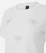Remera de algodón de corte regular, con cuello redondo y mangas cortas. Presenta aplicaciones de lazos decorativos realizados con pedrería brillante en la parte frontal.