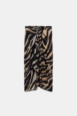 Falda pareo midi de tiro medio con estampado animal print tipo cebra, detalle de nudo drapeado en la parte delantera y abertura frontal. Cuenta con cierre de cremallera en la espalda.