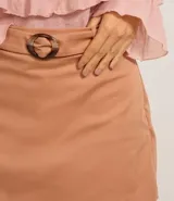 Short pollera color tostado de corte sastrero con cinturón incorporado y hebilla ovalada matizada.