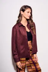 Camisa color marrón de gamuza sintética, de corte recto, con cuello clásico, cierre frontal con botones y mangas largas.