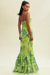 Vestido largo de tirantes finos, con escote drapeado y estampado de hojas tropicales en tonos verde y azul sobre fondo amarillo.