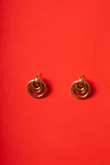 Aros de diseño geométrico formados por tres círculos concéntricos de metal dorado pulido, con cierre de perno.