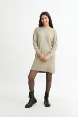 Vestido tipo sweater color blanco, de corte recto y largo hasta la rodilla, con cuello redondo y mangas largas.