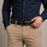 Cinturón reversible de cuero con hebilla metálica rectangular. Presenta una cara externa en color negro y una cara interna en color marrón.