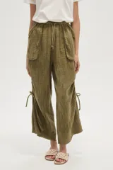 Pantalón ancho de algodón color verde militar, con tiro medio, bolsillos frontales grandes y tiras ajustables a los costados de las piernas.