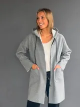 Montgomery largo de color gris melange, con capucha, cierre frontal y bolsillos delanteros amplios. Diseño de corte recto y estilo casual.