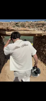 Camisa de waffle color crema con cuello polo, mangas cortas y bordado marrón en la espalda.