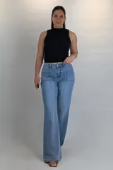 Pantalón jean de corte oxford y tiro medio, en tono azul intermedio. Cuenta con costuras verticales decorativas en el frente y bolsillos simulados con solapa a los costados de las caderas.