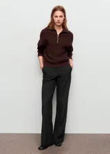 Pantalón de traje de tiro medio, diseño recto y largo, con bolsillos laterales y traseros de ribete. Cuenta con trabillas y cierre frontal con botón, gancho y cremallera.