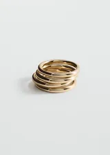 Pulsera rígida de acero dorado de diseño ancho y multilinea, con acabado brillante.