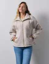 Campera beige capitoneada con capucha, cierre frontal y bolsillos laterales.