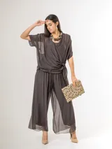 Pantalón de seda italiana con forro de viscosa elastizada, de corte holgado y diseño fluido, con detalles de paillettes en los costados y cintura elastizada.