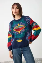 Sweater de tejido de punto con diseño geométrico multicolor sobre base azul marino, cuello redondo y puños acanalados.