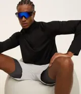 Remera deportiva térmica de manga larga color negro, con cuello alto y cremallera frontal. Presenta sisas raglán y recortes, sin estampado.