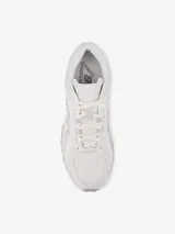 Championes urbanos New Balance modelo 204L, inspirados en el running de los años 2000, en color blanco con detalles en gris claro. Confeccionados en gamuza y malla, presentan la característica 'N' en los laterales y líneas arqueadas en el diseño.