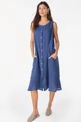 Vestido midi celeste de lino italiano, sin mangas, con escote redondo y cierre frontal abotonado con bolsillos laterales y corte holgado.