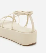 Sandalias flatform color crema, con tiras finas y plataforma plana. Presentan tiras largas para atar alrededor del tobillo.