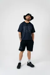 Short negro oversize con logo triangular estampado en gris en la pierna izquierda.