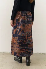 Falda midi con estampado geométrico difuso en tonos azul y marrón.