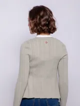 Cardigan de punto acanalado en color marrón, con escote en V, cierre frontal con botones a tono y mangas largas ajustadas.