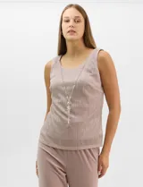 Conjunto de tres piezas compuesto por una musculosa recta, un cardigan liviano de frente abierto con mangas 3/4 y un pantalón de seda fría. La musculosa y el cardigan están confeccionados en tejido plisado con hilos metalizados tornasolados. Incluye collar removible y forro interno a tono.