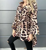 Camisola blanca de corte holgado con cuello alto y mangas largas con puños anchos abotonados.