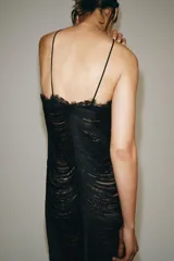 Vestido largo negro de la ZW Collection Limited Edition con cuello halter, espalda descubierta, detalle de flecos texturizados en toda la prenda y terminación de encaje en el bajo. Cuenta con cierre lateral con cremallera oculta.