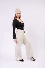 Pantalón wide leg color crudo de tiro medio, con diseño de cinco bolsillos y cierre frontal con botón y cremallera.