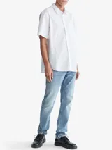 Camisa blanca de manga corta con cierre frontal con botones y bolsillo de pecho.