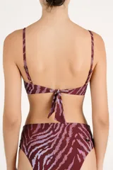 Top de bikini estructurado tipo corsetero, con aro, tirantes finos con tachas metálicas y diseño con estampado animal print en tonos bordó y rosado.