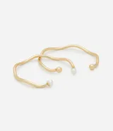 Kit de dos brazaletes rígidos de metal con diseño ondulado y acabado en tono dorado claro.