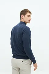 Buzo azul marino de tejido de punto con cuello alto y medio cierre con cremallera.