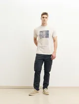 Remera color petróleo de manga corta con estampa de un edificio y texto en el frente.