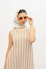 Vestido corto de punto con rayas verticales en tonos beige y crema, sin mangas y cuello redondo.