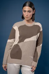 Buzo de punto confeccionado en lana, con cuello redondo y diseño abstracto que simula un paisaje. Presenta puños y ruedo acanalados.