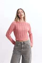 Sweater de punto color mostaza, con diseño de ochos y textura calada. Tiene cuello redondo, mangas largas y terminaciones acanaladas en puños y cintura.
