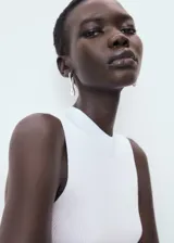 Top de punto canalé color blanco, de diseño entallado con cuello redondo y tirantes anchos sin mangas.
