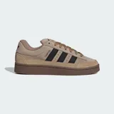Championes Adidas Campus ST de estilo urbano inspirado en los años 90. Presentan un exterior de gamuza y lona en tonos marrones con las icónicas tres tiras laterales en color negro. Cuentan con suela de caucho resistente y cierre mediante cordones.