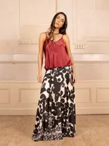 Falda larga acampanada con estampado de espirales en blanco y negro, cuenta con un lazo ajustable en la cintura.