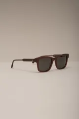 Lentes de sol color marrón con montura cuadrada y lentes grises.