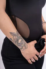 Body negro con cuello alto, mangas sisa y transparencias de tul en el escote y los laterales.