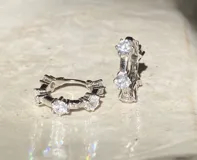 Par de aros tipo argolla de plata 925 con acabado en oro de 18k, adornados con circonitas.