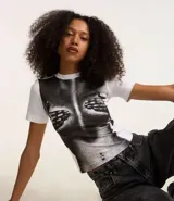 Remera blanca de algodón con cuello redondo y mangas cortas. Estampado frontal con imagen de un cuerpo femenino cubierto por manos.