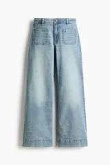 Jean de denim de algodón con tiro alto y pierna amplia de estilo wide leg. Presenta bolsillos tipo parche en la parte delantera y un lavado claro con efecto desgastado.